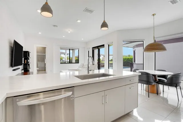 a kitchen with stainless steel appliances granite countertop a sink and a refrigerator