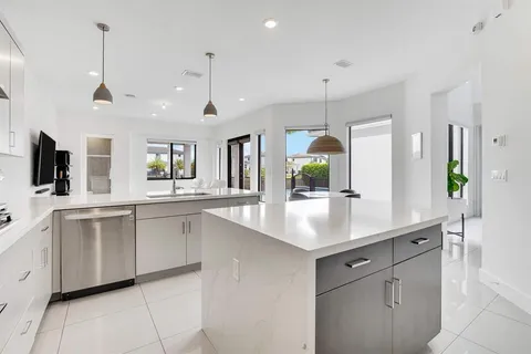 a kitchen with white cabinets and chandelier