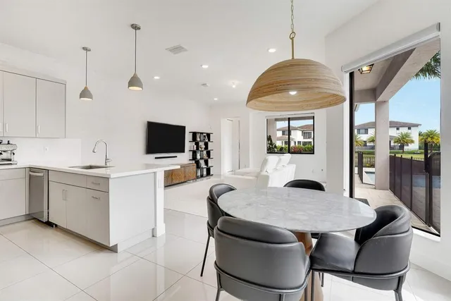 a kitchen with stainless steel appliances kitchen island granite countertop a sink a stove a table and chairs