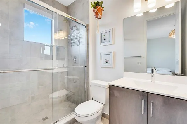 a bathroom with a sink a toilet and shower