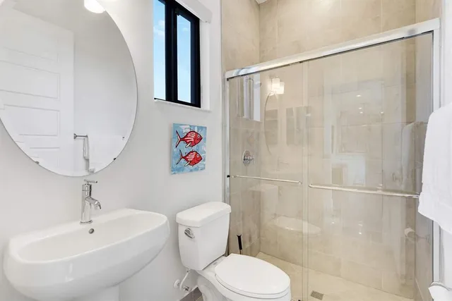 a white toilet sitting next to a bathroom sink