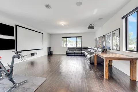 a living room with furniture flat screen tv and wooden floor