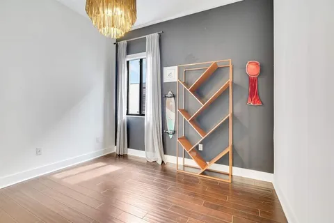an empty room with wooden floor and entryway