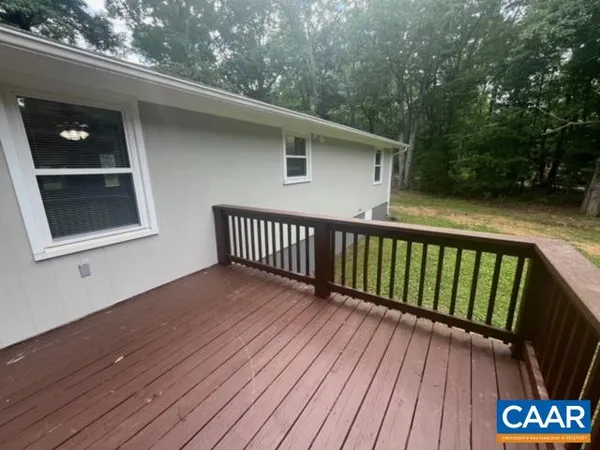 a view of backyard with a deck and wooden floor
