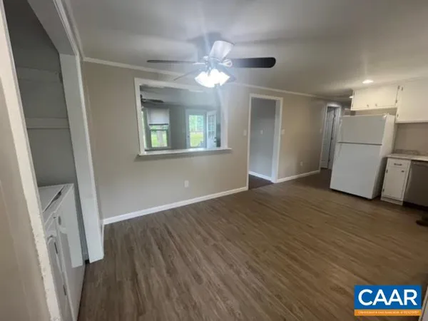 a view of empty room with wooden floor