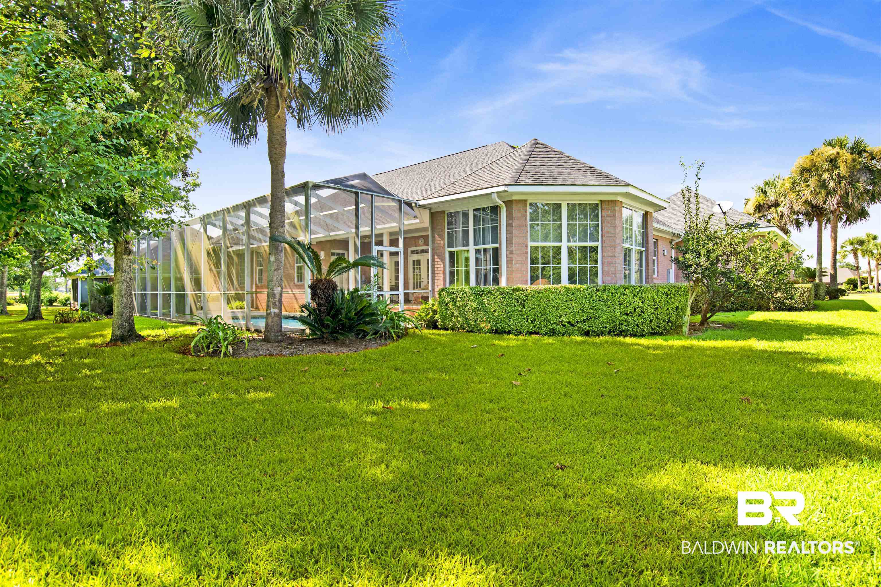 23014 Carnoustie Drive Foley, AL 36535 - Photo 47 of 49 Back of property featuring a yard, glass enclosure, a shingled roof, an outdoor pool, and brick siding