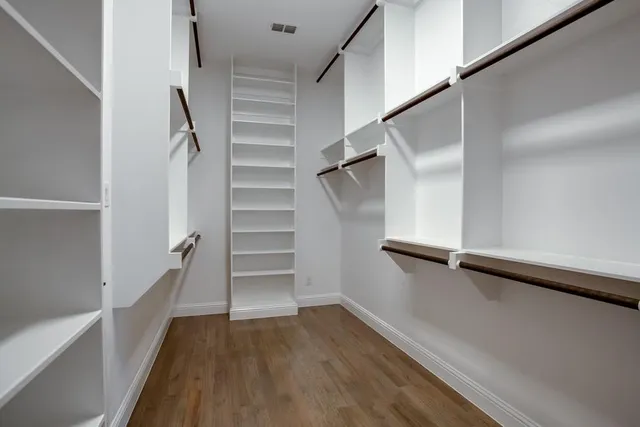 an empty room with ceiling fan and windows