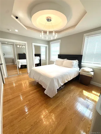 a bedroom with a large bed and a chandelier