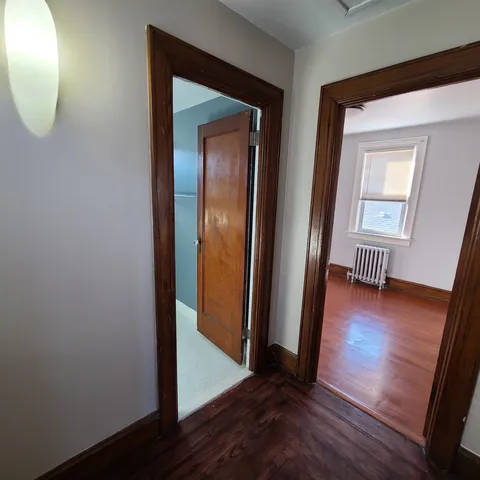 a view of a hallway with wooden floor and a mirror