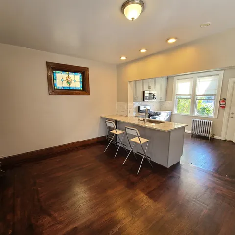 a living room with a table chairs and a wooden floor