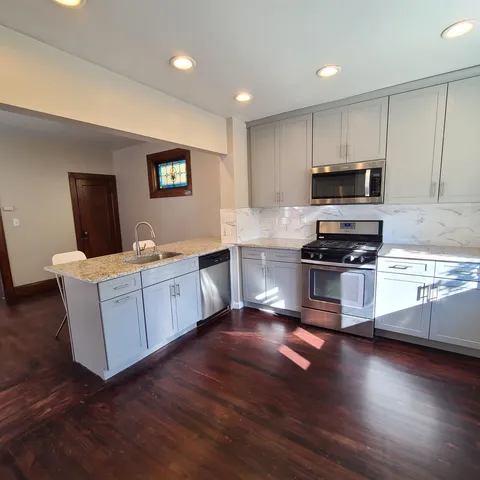 a kitchen with a refrigerator and a stove top oven