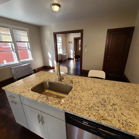 a kitchen with granite countertop sink and dishwasher