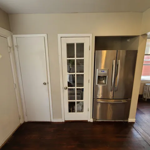 a view of empty room with wooden floor and window