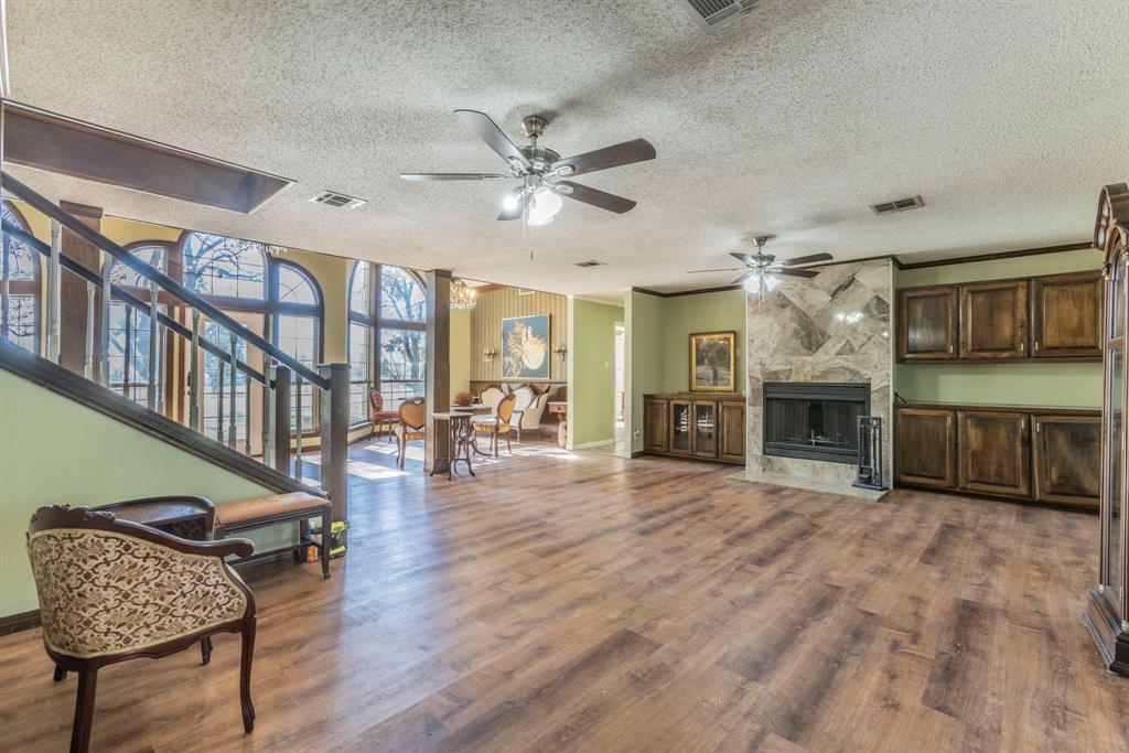 2622 Kendall Lane Waco, TX 76705 - Photo 12 of 40 Living room featuring a premium fireplace, dark wood-style flooring, a textured ceiling, stairway, and ceiling fan