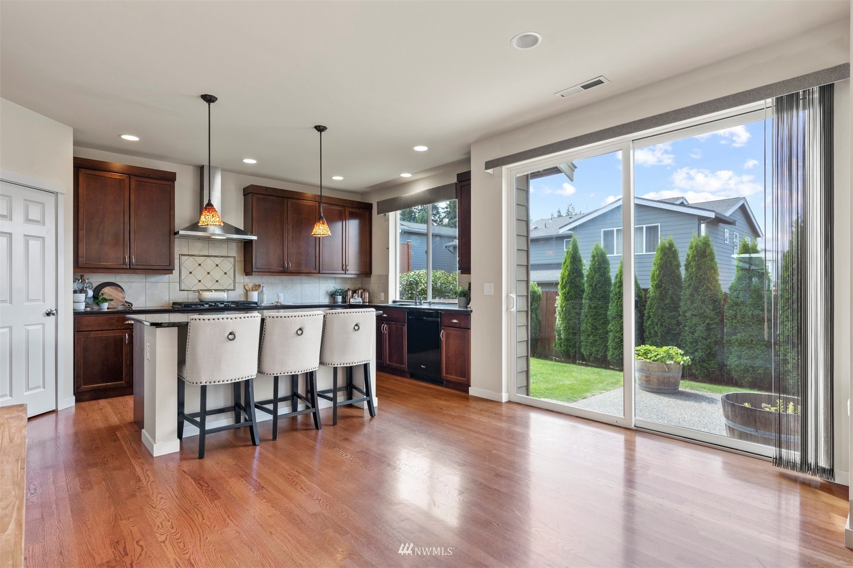 4320 230th Place Southeast Bothell, WA 98021 - Photo 13 of 31 a kitchen with stainless steel appliances granite countertop a stove a refrigerator a sink a dining table and chairs with wooden floor