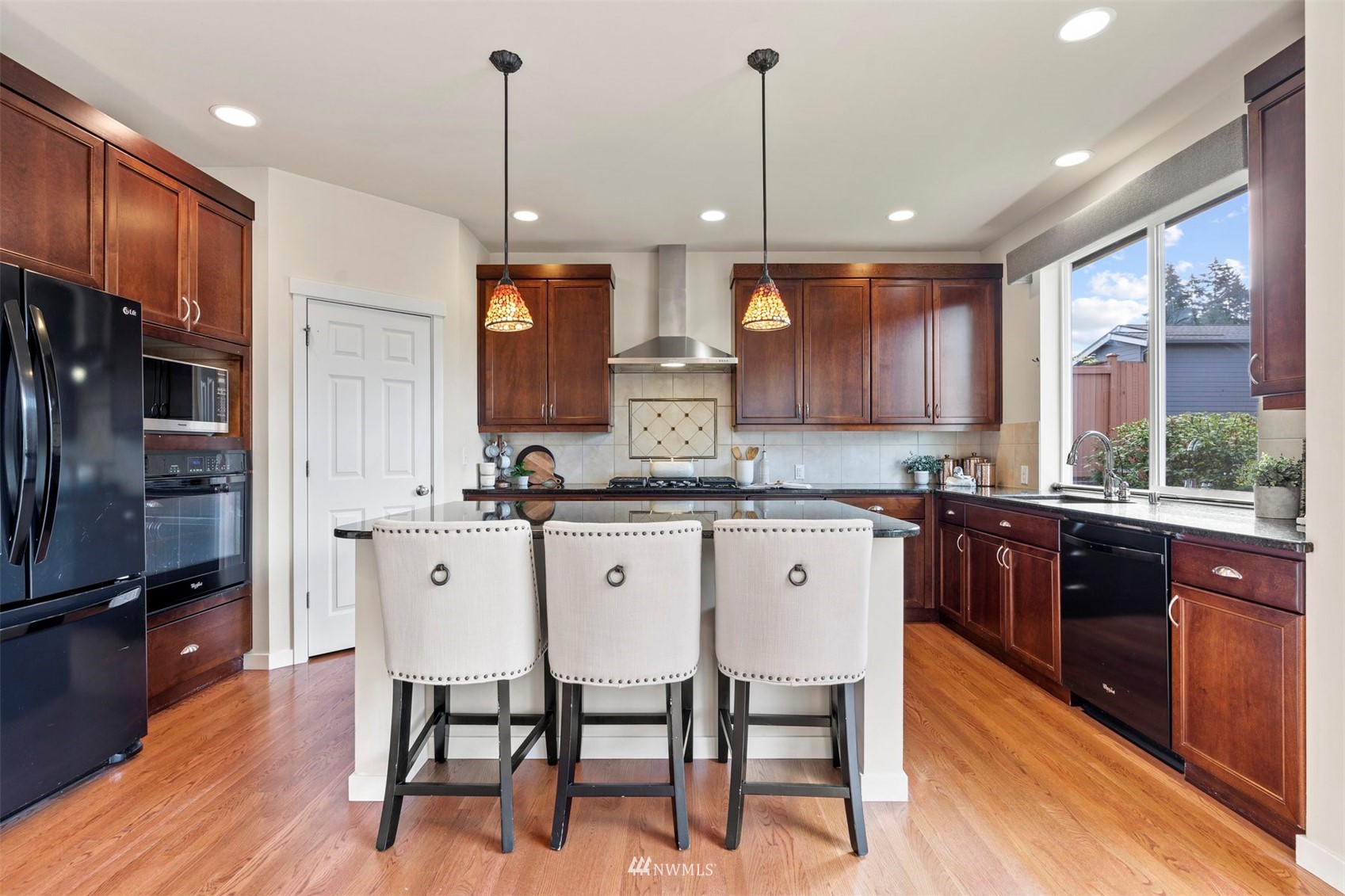 4320 230th Place Southeast Bothell, WA 98021 - Photo 14 of 31 a kitchen with stainless steel appliances granite countertop a kitchen island hardwood floor sink stove dining table and chairs