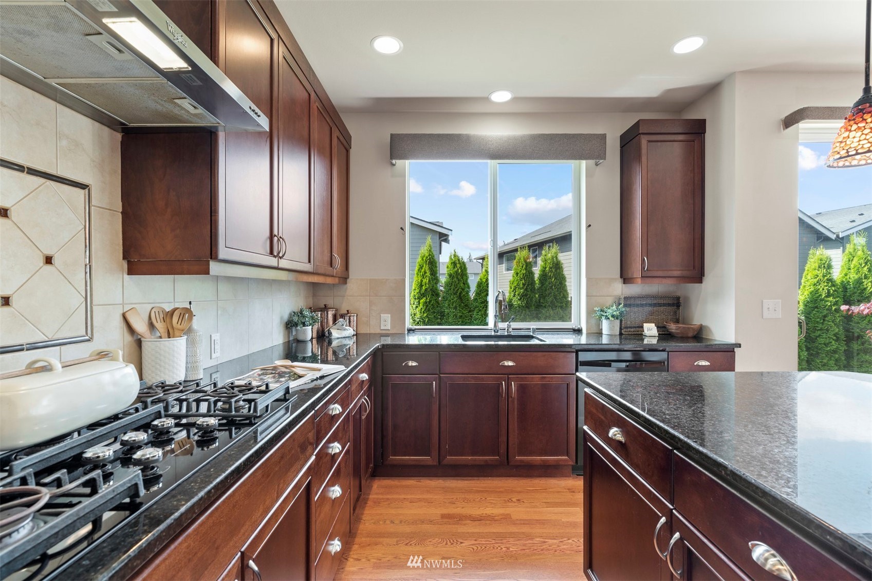 4320 230th Place Southeast Bothell, WA 98021 - Photo 15 of 31 a kitchen with kitchen island granite countertop a sink stainless steel appliances cabinets and a counter top space