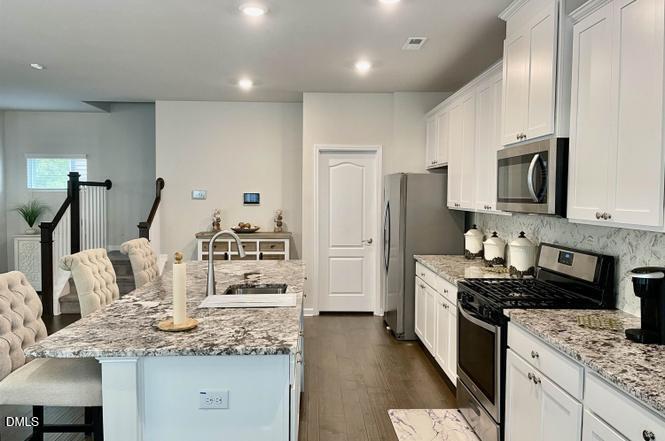 1807 Wrenn Road Durham, NC 27703 - Photo 17 of 43 a kitchen with kitchen island granite countertop a sink stainless steel appliances and cabinets