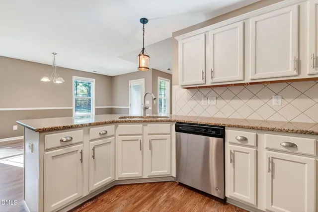 a kitchen with granite countertop white cabinets and white appliances