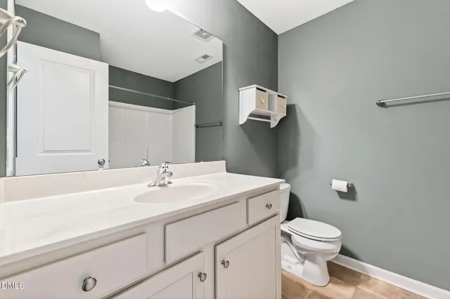 a bathroom with a sink a toilet and mirror