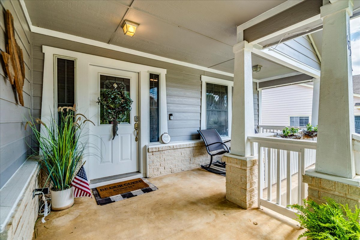 175 Wetzel Kyle, TX 78640 - Photo 8 of 27 A welcoming front porch features sturdy columns and light-colored siding, creating an inviting entry.
