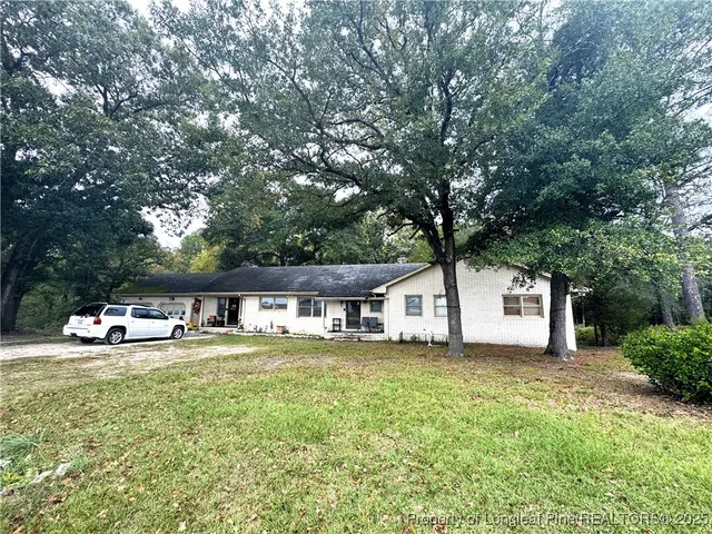 a view of a house with swimming pool and sitting area