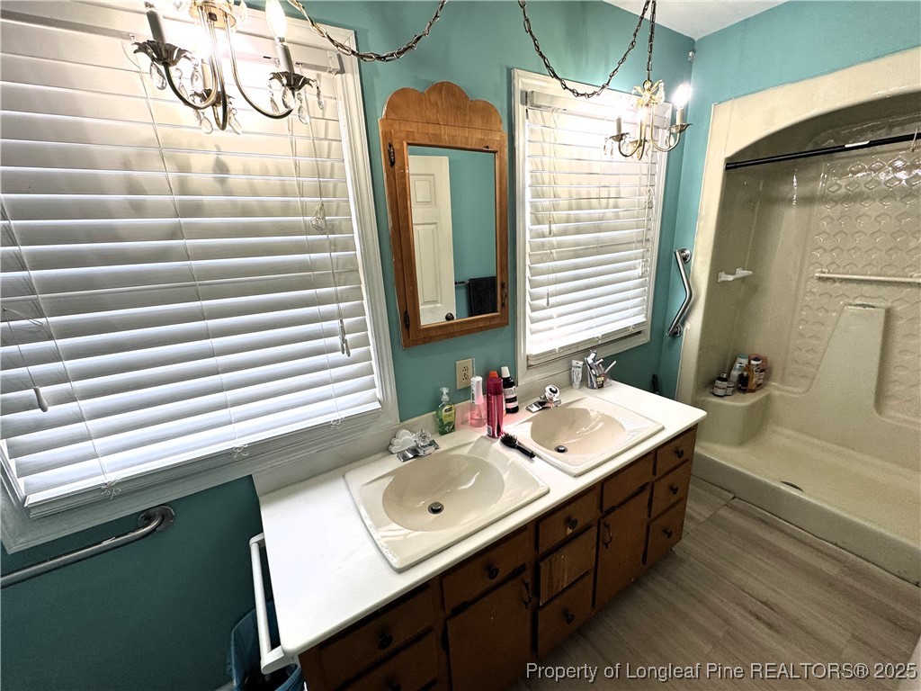 310 Old Hertford Ln Spring Lake Spring Lake, NC 28390 - Photo 22 of 30 a bathroom with a sink a mirror and a bathtub