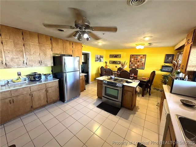 a kitchen with a refrigerator and wooden cabinets