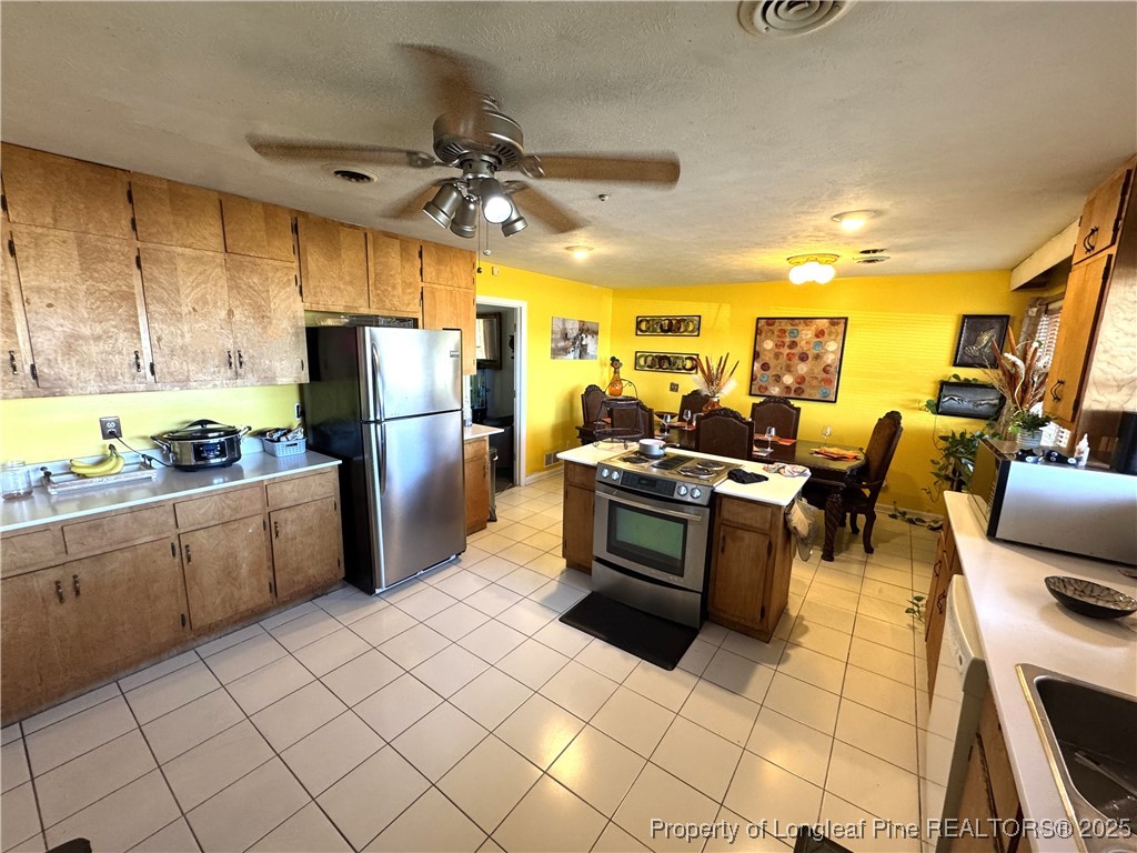 310 Old Hertford Ln Spring Lake Spring Lake, NC 28390 - Photo 6 of 30 a kitchen with a refrigerator and wooden cabinets