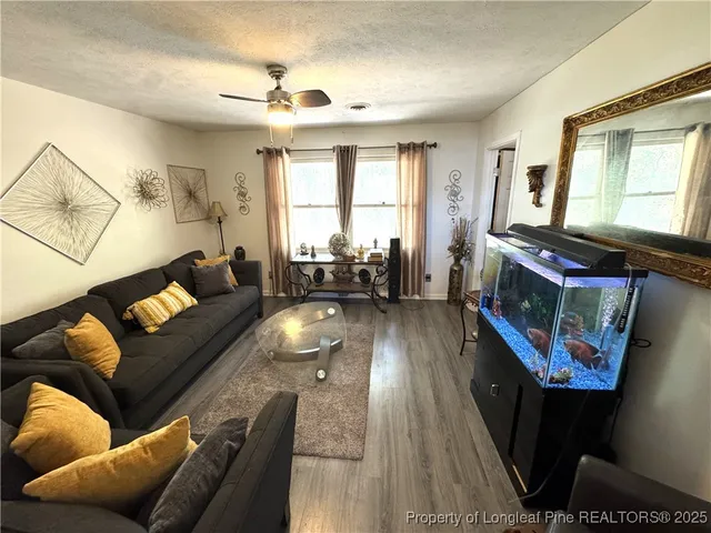 a living room with furniture and a wooden floor