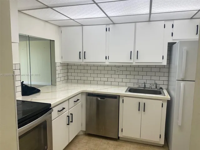 a kitchen with a sink cabinets and stainless steel appliances