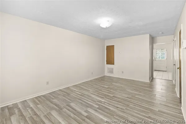 a view of empty room with wooden floor and fan