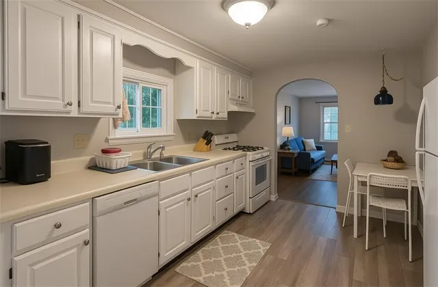 a kitchen with white cabinets and sink