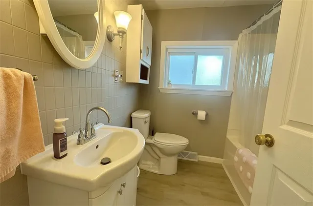 a bathroom with a sink a toilet and a mirror
