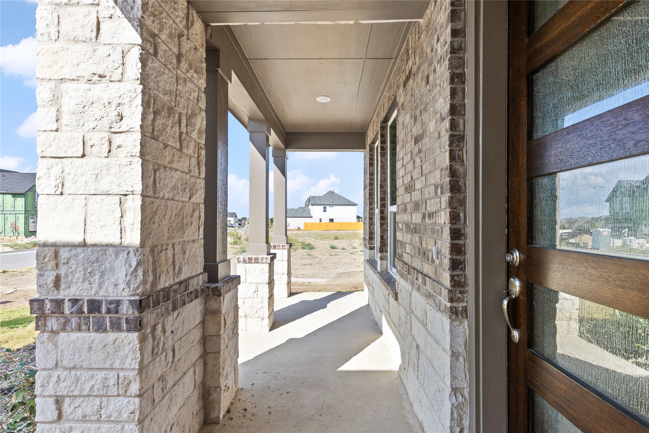 19705 Domino Champ Road Pflugerville, TX 78660 - Photo 5 of 38 A deep covered front porch features substantial stone pillars and a handsome wood entry door.