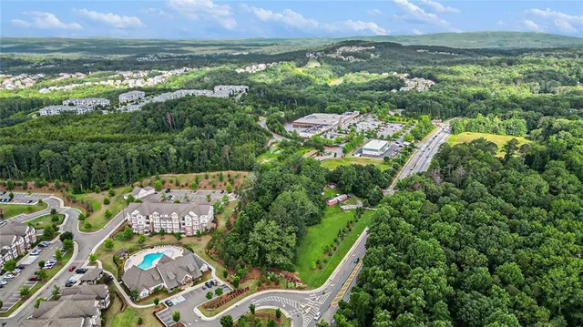 an aerial view of residential houses with outdoor space and trees