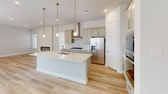 a large white kitchen with a large window and stainless steel appliances