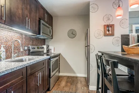 a kitchen with stainless steel appliances granite countertop a sink stove and refrigerator