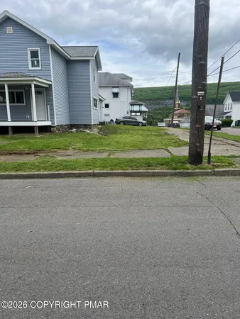 a view of a house with a big yard and palm trees
