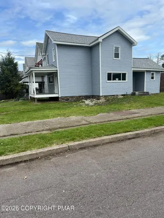 a front view of house with yard and parking