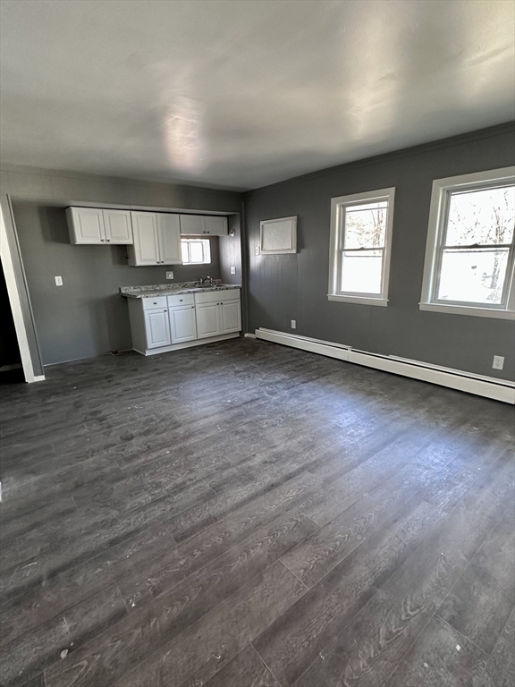 128 Mill Street Springfield, MA 01108 - Photo 5 of 14 an empty room with wooden floor and windows