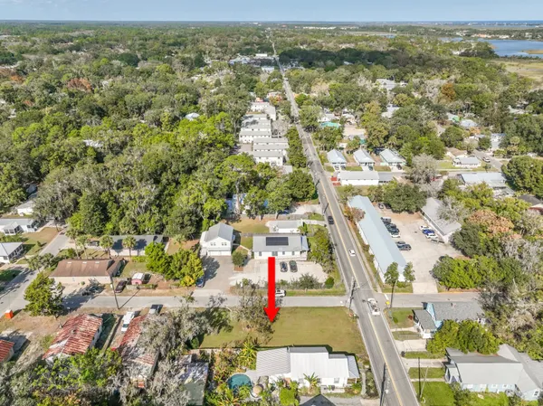 an aerial view of residential houses with outdoor space and trees