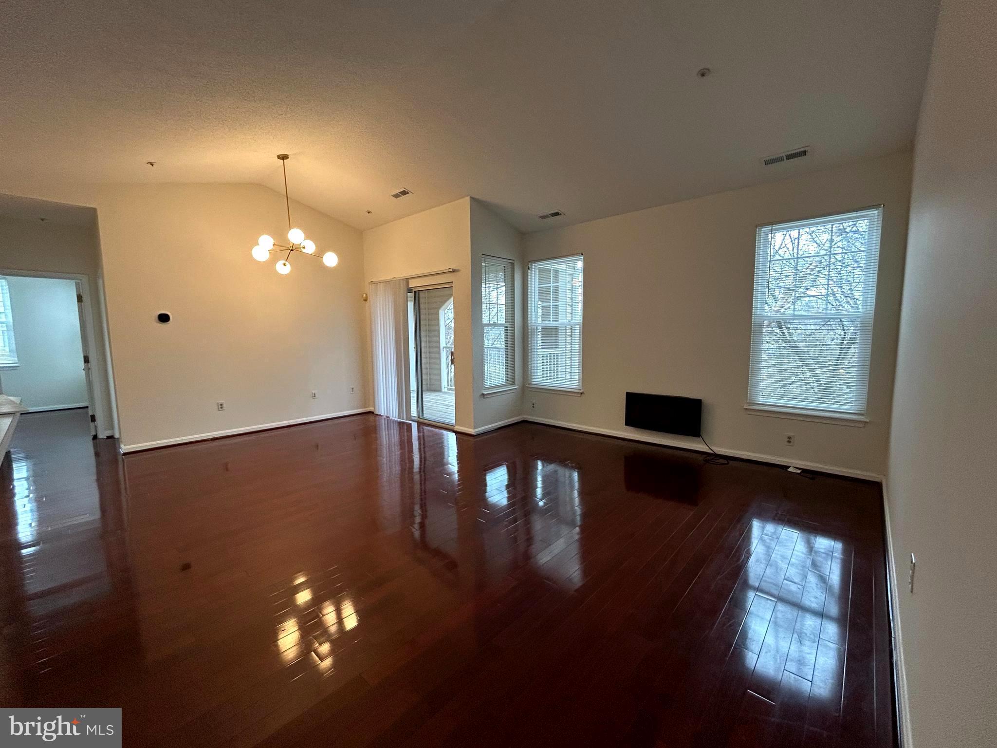 7204 Bogley Road, Unit 303 Baltimore, MD 21244 - Photo 2 of 15 a view of a livingroom with furniture wooden floor a chandelier and windows