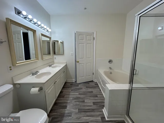 a spacious bathroom with a granite countertop sink mirror toilet and bathtub