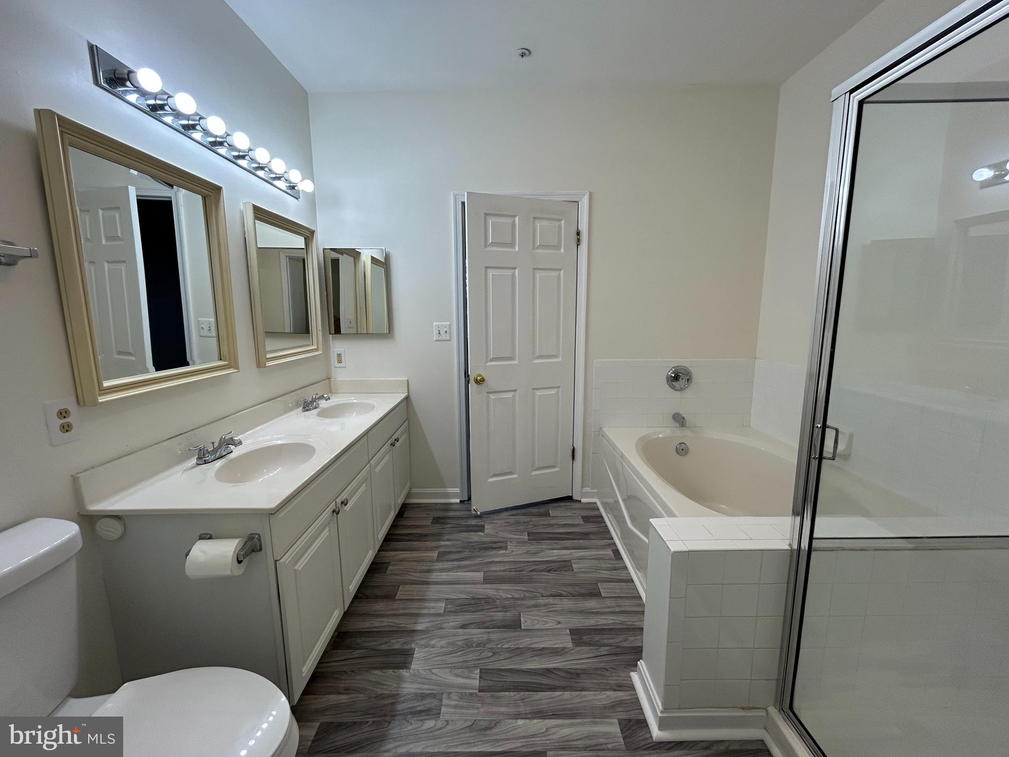 7204 Bogley Road, Unit 303 Baltimore, MD 21244 - Photo 5 of 15 a spacious bathroom with a granite countertop sink mirror toilet and bathtub