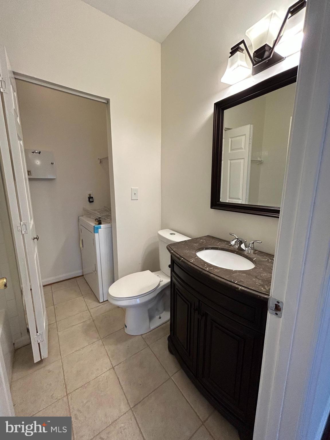 7204 Bogley Road, Unit 303 Baltimore, MD 21244 - Photo 9 of 15 a bathroom with a sink a toilet and mirror