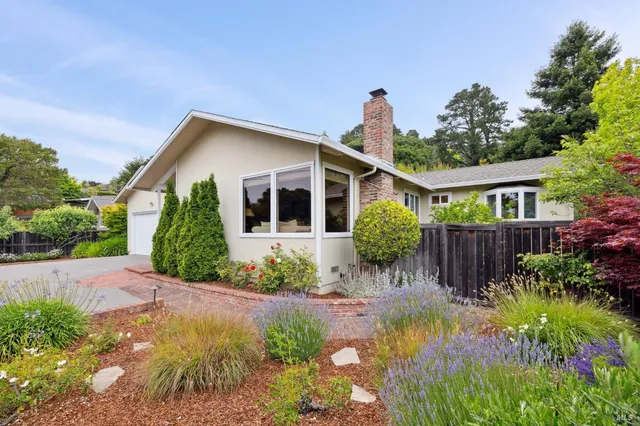 a front view of a house with a yard and potted plants