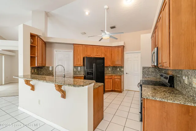 a kitchen with stainless steel appliances granite countertop a sink and a refrigerator