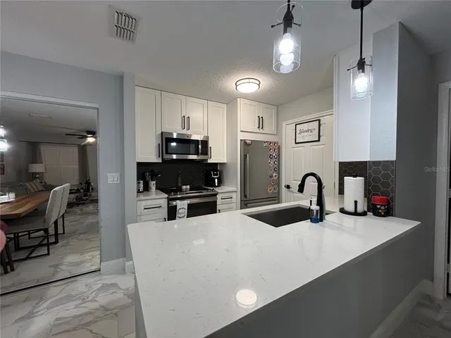 a kitchen with stainless steel appliances a stove sink microwave and cabinets