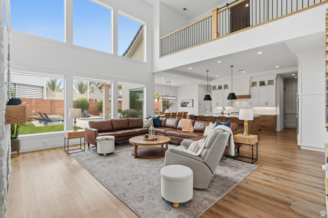2278 Tawny Ridge Circle St. George, UT 84790 - Photo 6 of 61 Double-height living space featuring expansive windows, wood-finish flooring, and a modern kitchen with pendant lighting and built-in cabinetry.